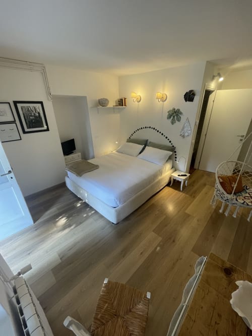 Camera moderna a La Cascina di Bea con letto matrimoniale, pavimento in legno, applique murali e vista sul giardino a Torre Boldone