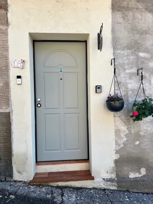 Entrance to Iris Double Room at La Cascina di Bea B&B in Torre Boldone, Bergamo, with gray door and hanging flower baskets