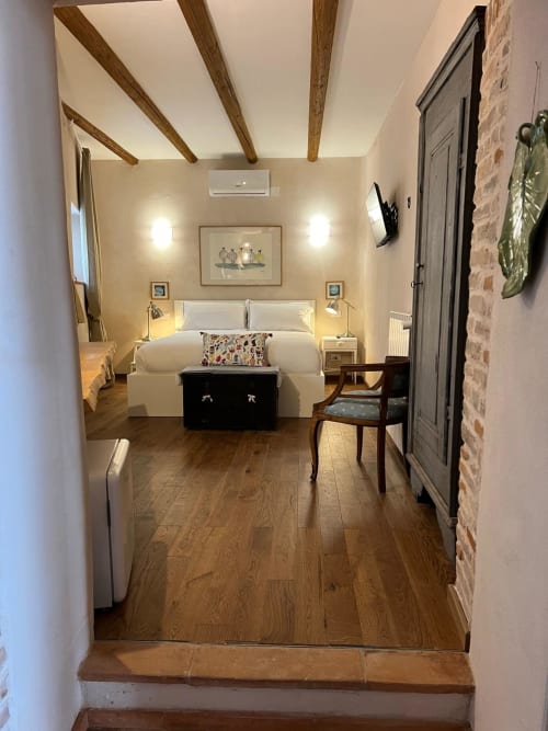 Camera Doppia Iris presso La Cascina di Bea B&B a Bergamo, con travi in legno a vista, biancheria bianca, pavimento in legno e