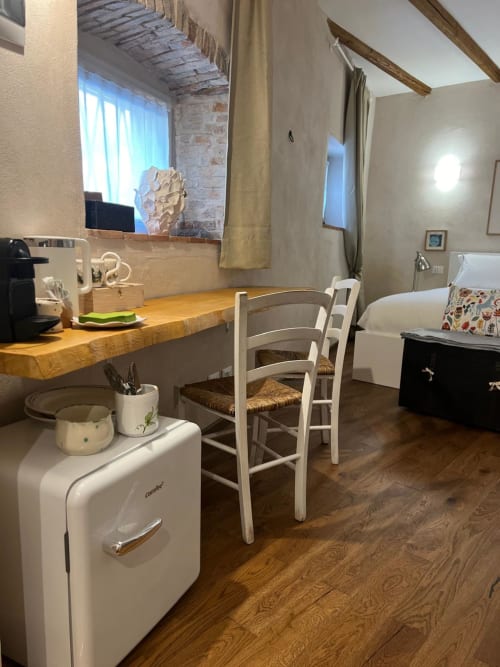 Iris Double Room at La Cascina di Bea B&B in Bergamo, featuring wooden desk, white chair, retro minibar, and bed with city