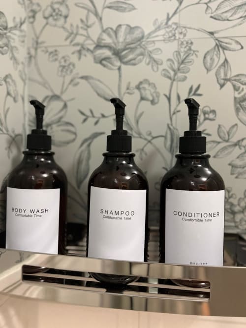 Three dark glass amenity bottles labeled Body Wash, Shampoo, and Conditioner by Comfortable Time at La Cascina di Bea in