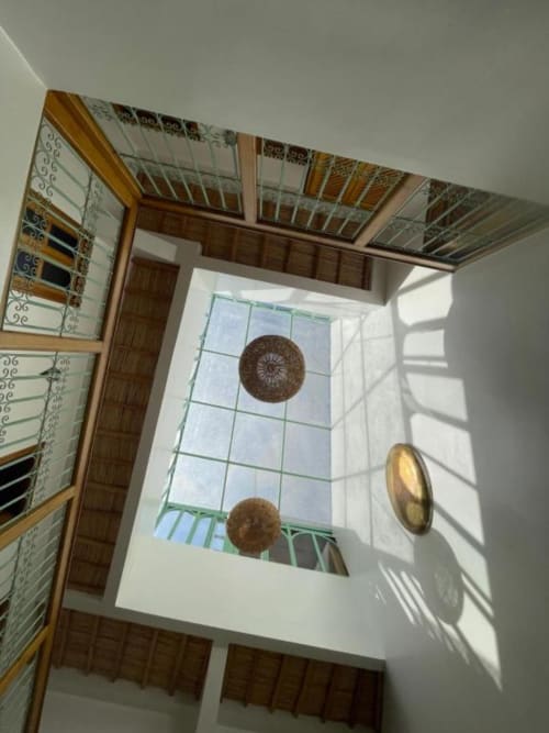 La chambre de Riad Madinina présente un plafond traditionnel avec des motifs de paniers tressés et une lucarne donnant sur la cour de Marrakech