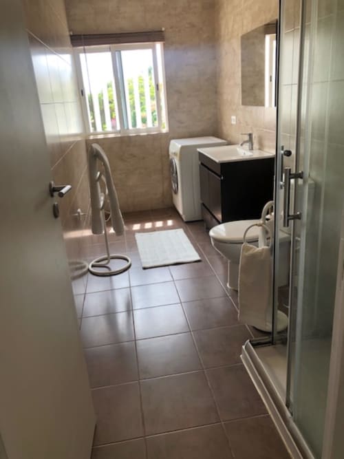 Banheiro moderno em Sintra Apartamentos com chuveiro aberto, pia com espelho, vaso sanitário e máquina de lavar em Sintra, Portugal