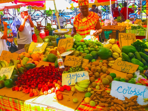 Marché coloré de fruits tropicaux à Petit Bourg, Guadeloupe avec vendeurs proposant mangues, agrumes et produits locaux.
