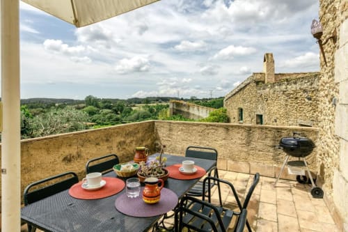 Terraza rústica de piedra en Can Gat Vell con mesa de comedor y vistas al campo, Girona, Empordà