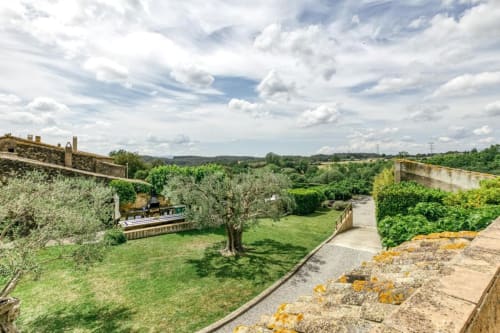 Jardín Can Gat Vell con olivos, césped cuidado y vistas al campo de Empordà, Girona