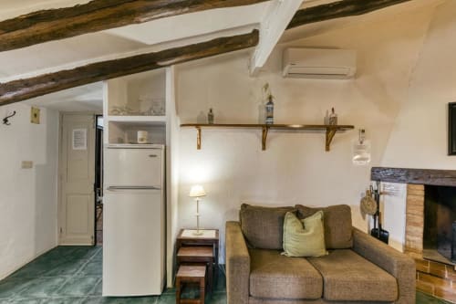 Acogedor estudio en Can Gat Vell B&B en Girona con vigas vistas, chimenea, sofá y kitchenette