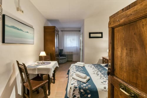 Dormitorio rústico en la casa rural Can Gat Vell en Girona, con muebles de madera, colcha azul estampada y decoración tradicional