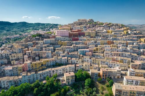 Affascinante villaggio di Vallata, Italia, con tradizionali edifici in pietra arroccati su pendii e paesaggio verdeggiante