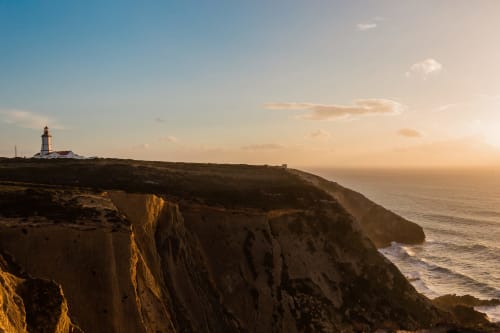 Lighthouse on coastal cliffs at sunset, Sesimbra Portugal