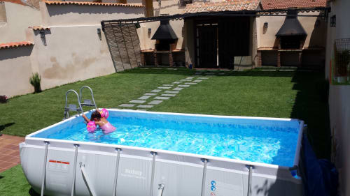 Piscina rectangular con flotador rosa en jardín cuidado del hotel Tradición Rural, Nieva España