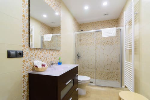 Baño moderno en Tradición Rural con paredes de mosaico, lavabo oscuro, ducha con cristal y toallero térmico