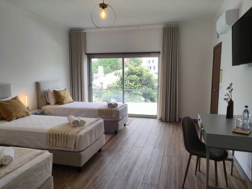 Triple room at Embaixada da Vila in Cascais with twin beds, garden view, modern furnishings and amenities