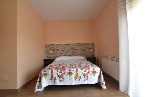 Acogedora habitación en Tradición Rural de Nieva con colcha floral y cabecero de madera