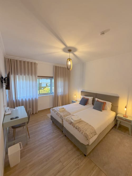 Spacious twin bedroom at Embaixada da Vila in Cascais with modern decor, work desk, and sea views