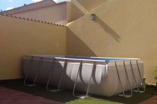 Piscina rectangular con estructura metálica en el patio del hotel Tradición Rural en Nieva, España