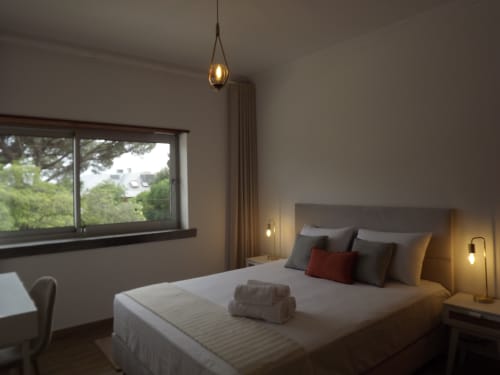 Modern double bedroom at Embaixada da Vila, Cascais with garden view, pendant lighting, and contemporary furnishings
