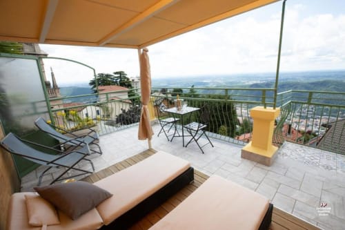 Terrazza Hotel Vista Lago con lettini, ombrellone e vista panoramica sul lago a Brunate, Italia