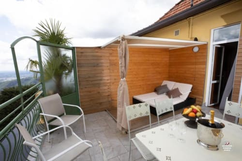 Terrazza dell'Hotel Vista Lago a Brunate con letto a baldacchino in legno, tavolo da pranzo, sedia e vista sulla valle