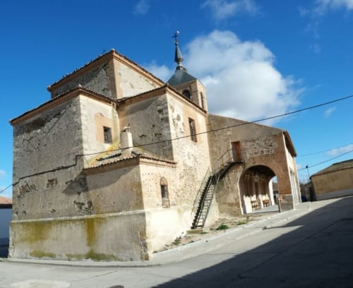 Iglesia de piedra histórica con campanario en Nieva, España, punto de referencia de hotel rural