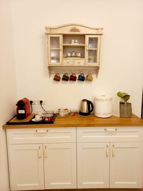 Angolo bevande in cucina presso La Suite del Giardino con bancone in legno, macchina da caffè, bollitore e mobile a parete