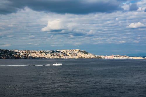 Vista panoramica della costa di Napoli con edifici fitti sulle colline e le acque blu della baia