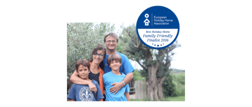 Familia sonriendo al aire libre en Can Gat Vell B&B en Girona, Empordà con distintivo European Holiday Home