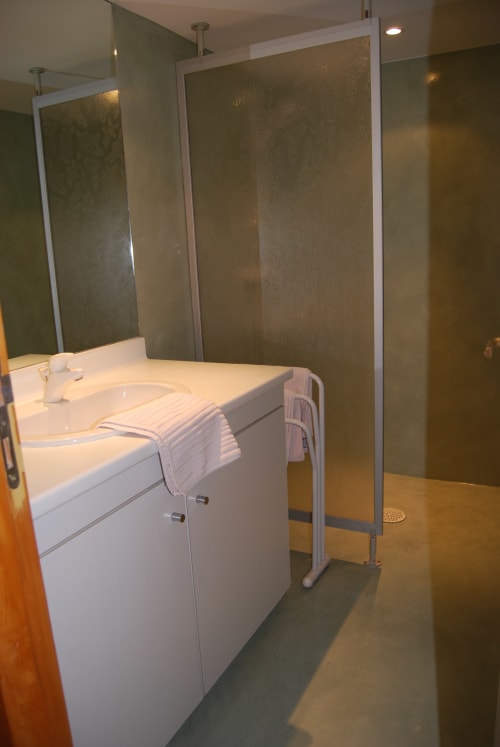 Salle de bain moderne avec meuble vasque blanc, porte-serviettes et douche à paroi vitrée dépoli aux Chambres d'hôtes le Grand Bienfaisy