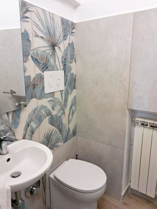 Bagno moderno con carta da parati botanica tropicale presso La Suite del Giardino, Napoli