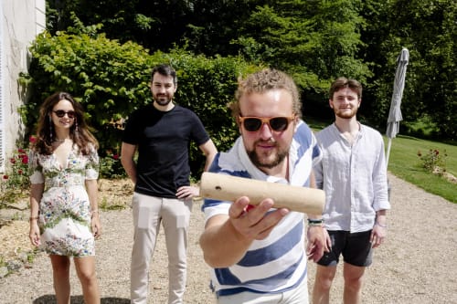 Groupe de quatre invités au Château de Vaux Morvan à Étang sur Arroux tenant un parchemin dans un jardin