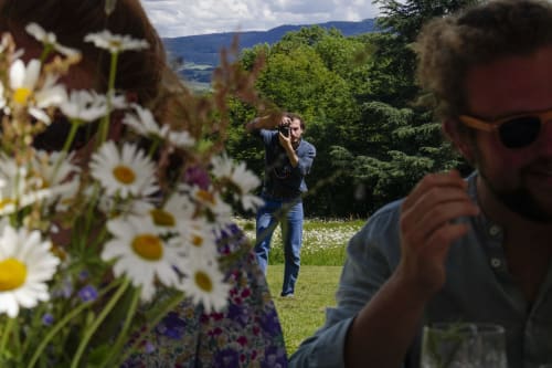Des hôtes photographiant les fleurs sauvages dans les jardins du Château de Vaux Morgan, un gîte de charme en Étang