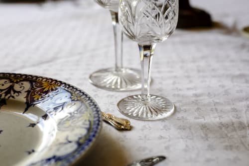 Élégante mise de table au Château de Vaux Morvan avec verres en cristal et assiette décorée