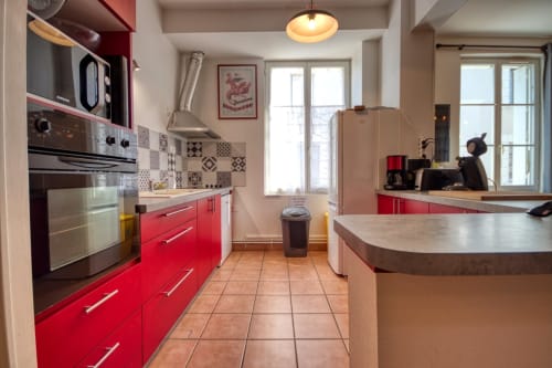 Cuisine moderne rouge et blanc avec électroménagers en acier inoxydable aux Vacances en Touraine, Souvigny-de-Touraine