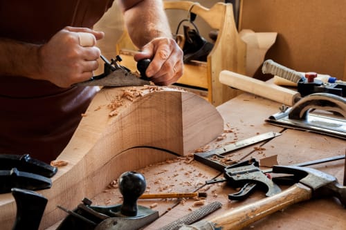 Artisan utilisant un rabot à main sur du bois à Vacances en Touraine, Souvigny-de-Touraine