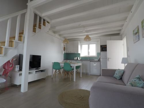 Apartamento Flamingo de planta aberta em Recantus Comporta com cozinha moderna, zona de refeições com cadeiras verdes e sala