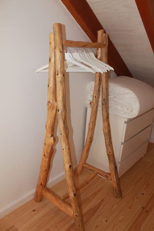 Cabideiro de madeira com cabides brancos no Apartamento Flamingo em Recantus Comporta, Comporta Portugal