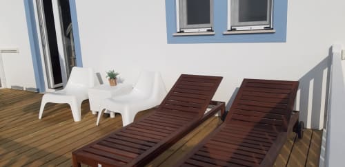 Varanda do Apartamento Flamingo no Recantus Comporta com espreguiçadeiras, assentos brancos e vista para o jardim de Comporta, Portugal