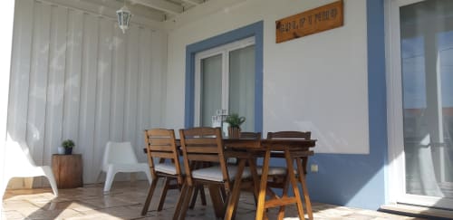 Apartamento Dolphin no Recantus Comporta com mesa de jantar em madeira, parede azul e vista para o jardim em Comporta, Portugal
