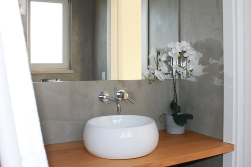 Modern bathroom sink at Recantus Comporta Egret Apartment with white orchid plant and wooden countertop