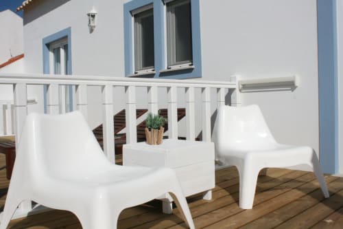 Stork Apartment balcony at Recantus Comporta with white modern chairs and wooden deck overlooking city view