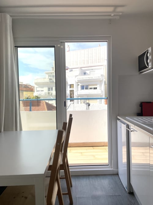 Modern kitchen with balcony view at Vila Alexandra hostel, Costa da Caparica