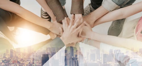 Unité d'équipe à Home Horizon SBL Limoges : mains serrées symbolisant la collaboration et l'excellence en hospitalité