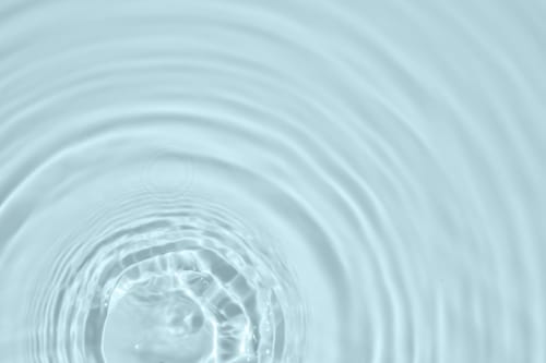 Douces ondulations d'eau formant des cercles concentriques, symbolisant la détente paisible à l'hôtel Home Horizon SBL à Limoges