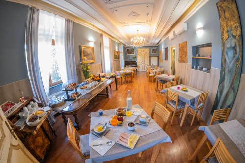 Elegante sala colazioni dell'Hotel Vista Lago a Brunate con tavoli in legno, piatti placcati, buffet e vista lago