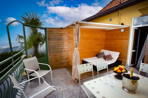 Balcone soleggiato con letto, lettino e vista panoramica sulla città presso Hotel Vista Lago, Brunate