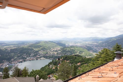 Vista del Lago di Como dalla camera dell'Hotel Vista Lago a Brunate, Italia, con paesaggio montano e terrazza sul tetto