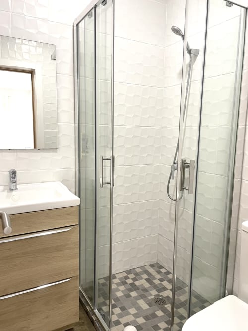 Modern bathroom with glass shower enclosure at Vila Alexandra hostel in Costa da Caparica, Portugal