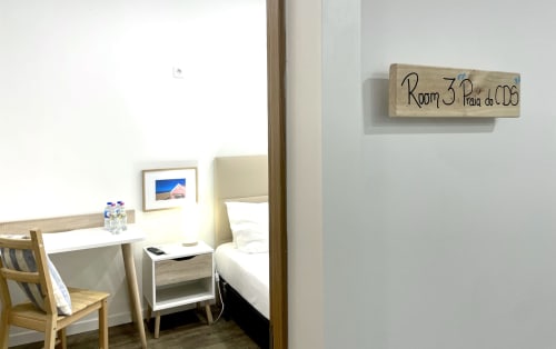 Room 3 at Vila Alexandra hostel in Costa da Caparica featuring a bed, desk with chair, and wooden room sign