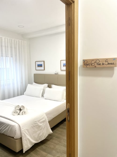 Room 6: Praia da Sereia at Vila Alexandra hostel in Costa da Caparica, Portugal. Clean bedroom with queen bed, white pillows,