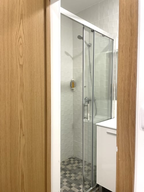 Modern shower enclosure with glass doors at Vila Alexandra hostel in Costa da Caparica, Portugal
